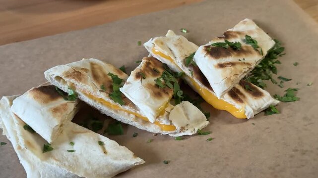 Grilled cheese wrap Fresh chicken wrap cut in half on a dark plate. Delicious tortilla filled with grilled meat and vegetable. Tasty street food meal for quick lunch or snack concept in a cafe.