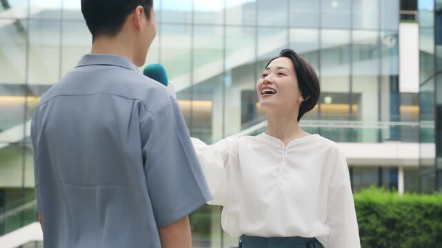 街で男性にインタビューする女性リポーター