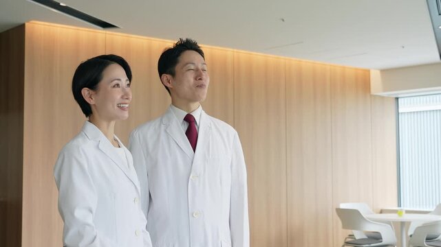 画面を見ながら会話する白衣の男女グループ
