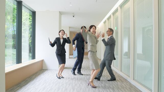オフィスでダンスする男女ビジネスパーソンのグループ