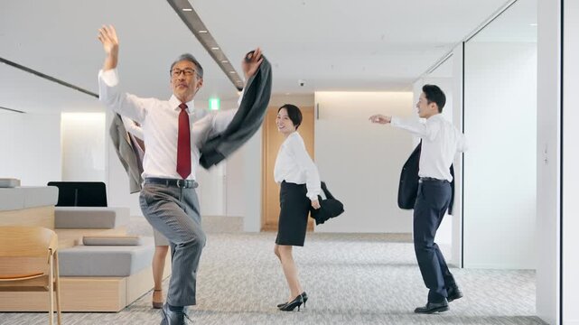 オフィスでダンスするビジネスパーソンのグループ