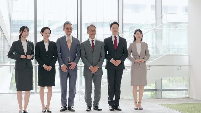 ロビーに整列する幅広い世代の男女ビジネスパーソンのグループ