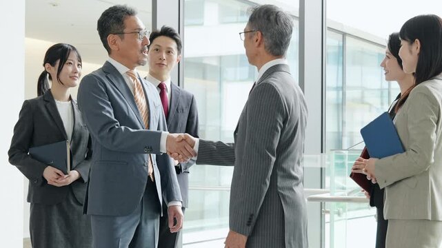 オフィスで握手するビジネスパーソンのグループ