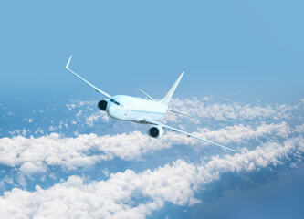 Obraz premium White passenger airplane flying in the sky amazing clouds in the background - Travel by air transport