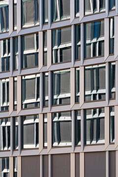Modular facade with windows arranged in a tight grid across a building exterior, showing urban architecture pattern and repeated detail