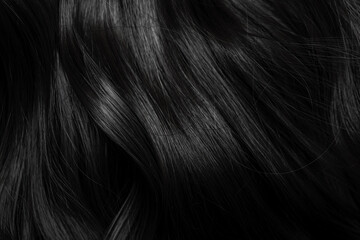 Naklejka premium Brunette or black hair. Female long dark hair in black. Beautifully laid curls. Closeup texture in a dark key. Hairdressing, hair care and coloring. Shading gray hair. Background with copy space.