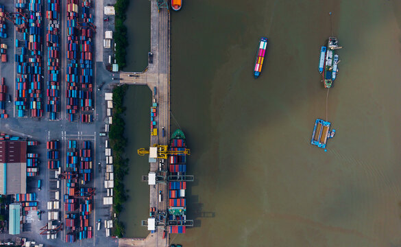 Aerial top view of cargo port and vessels with stacked containers for logistics background and transport infrastructure