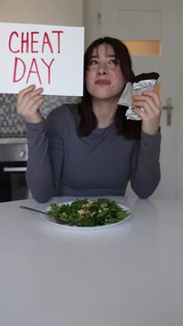 Vertical screen happy woman enjoys chocolate during cheat day while trying to balance healthy eating routine and weight loss goals before summer season