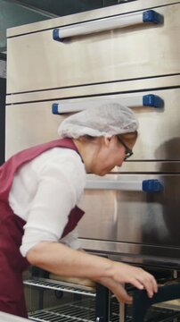 Working process in he bakery, cook checks raw pies in the refrigerator