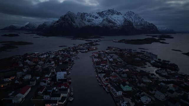 Views of a small town by the water with mountains in the background at night in Norway
