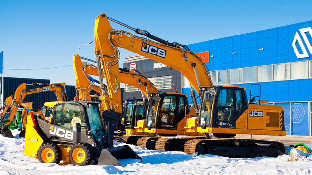 Riga, Latvia - February 8, 2026: New JCB crawler excavators and a mini bulldozer on the street near a car dealership with a blue sky in the background