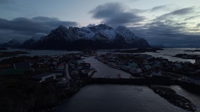 Aerial view of mountains and town by the water during evening hours in Norway