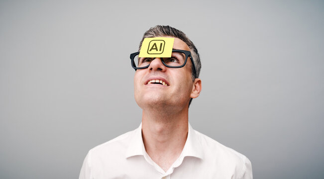 An enthusiastic man with a Post-it note on his forehead that says &ldquo;AI.&rdquo;