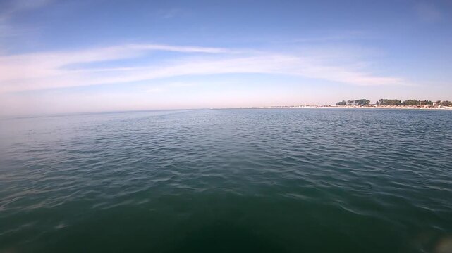 View of the sea and the coast from a floating motorboat on a sunny summer day. Sea view from fast moving boat. Seascape, sea landscape. Concept of travel, vacation, tourism, relaxation, rest, holidays