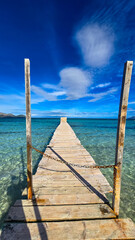Fototapeta premium Wooden pier at Playa de Muro with turquoise sea and blue sky in Mallorca
