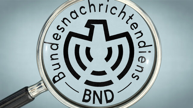 Eine Lupe vergr&ouml;&szlig;ert das Logo des deutschen Bundesnachrichtendienstes (BND) auf wei&szlig;em Untergrund