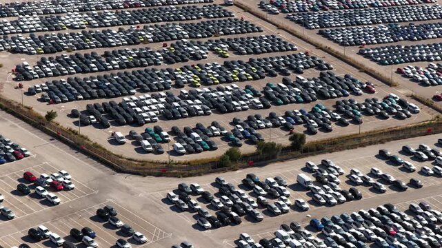 Huge parking lot featuring rows of brand new cars from a car factory, ready for export and sale in the automotive market, showcasing the large scale of vehicle manufacturing and distribution