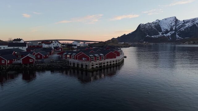 Scenic view of homes on water during sunset in a coastal village with mountains