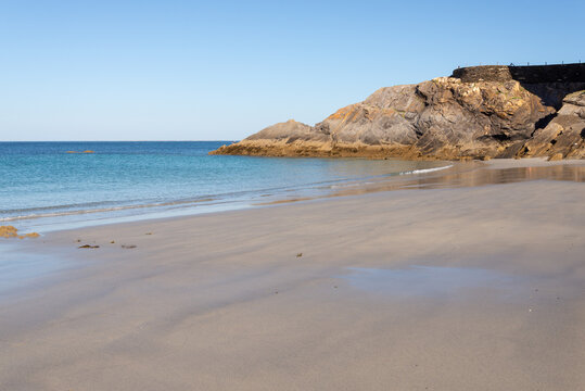 View of Le Paradis (Paradise Area) on Portez Beach Le Conquet Finistere Brittany France showing smooth sand, rocky shoreline and calm blue sea under clear summer sky