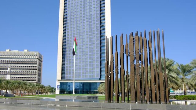 Bright daylight reveals Etihad Towers rising over Abu Dhabi, clean lines reflecting sun, modern silhouette shaping strong city mood, clear sky framing powerful architecture in calm summer air.