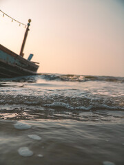 Fototapeta premium Serene shoreline capturing waves by aged pier with subdued sky
