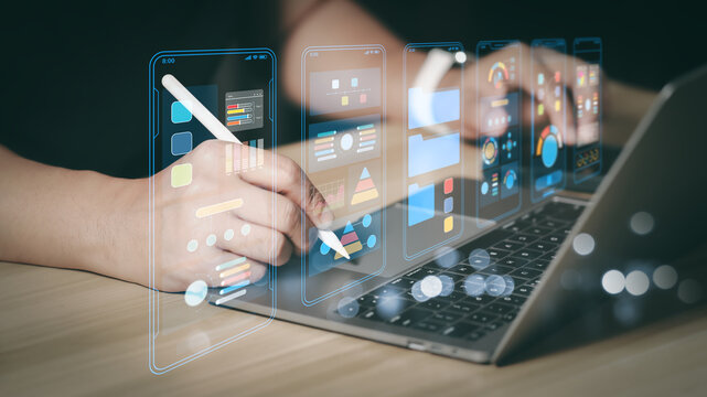 Designer using stylus and laptop for mobile UI UX design and data analysis dashboard. Concept of digital marketing management and financial information technology with virtual screen.