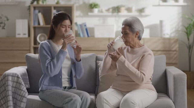 Happy generational family conversation between mother and daughter, talking and smiling on couch in living room caring, special moment showing love and healthy lifestyle