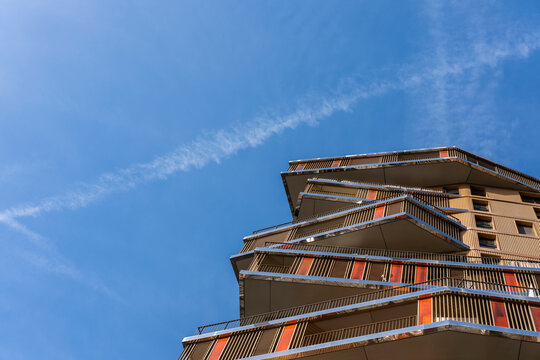 Against open sky, a Paris Rive Gauche apartment facade stacks modern residential architecture into urban housing terraces with graphic lines