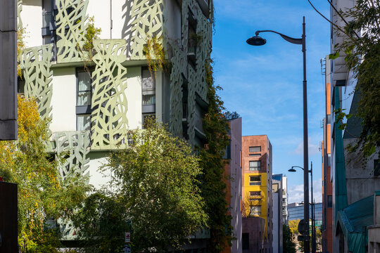Trees soften a Paris Rive Gauche apartment facade, where modern residential architecture meets urban housing texture, windows, and street light
