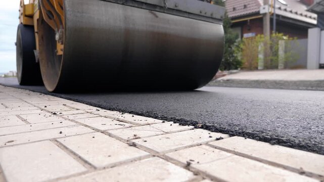 Single Drum Road Roller Compacting Fresh Asphalt Along Paving Edge Close Up