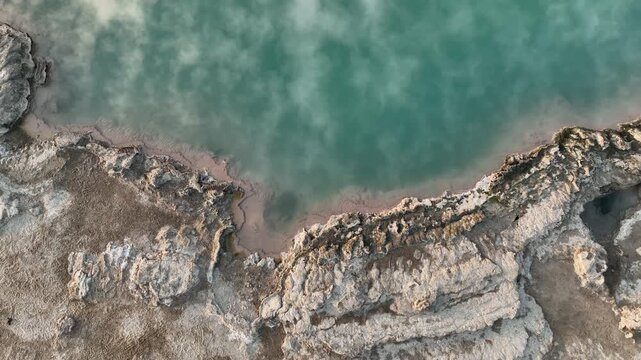 Aerial view of the turquoise geothermal pool and white mineral crusts of the Danakil Desert Dalol, Afar, Ethiopia.