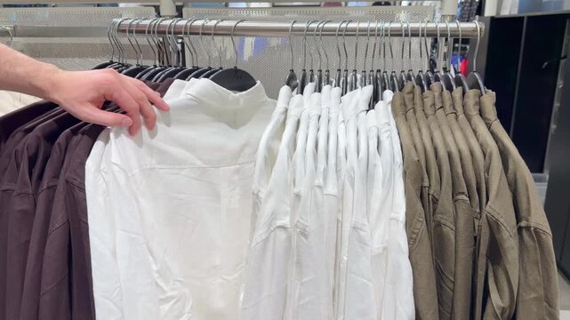 Clothes store in shopping mall.Blurred store aisle with hanging clothing racks