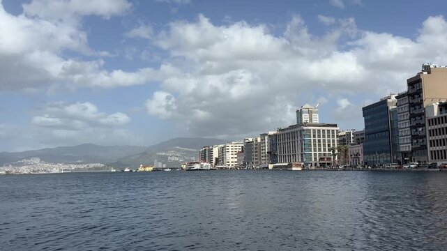 Wide Angle Sea View of Izmir Pasaport Waterfront Promenade City Skyline and Distant Mountains under Cloudy Sky Footage