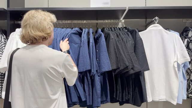Clothes store in shopping mall.Blurred store aisle with hanging clothing racks