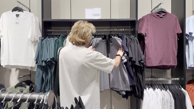 Clothes store in shopping mall.Blurred store aisle with hanging clothing racks