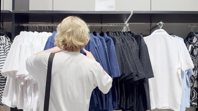 Clothes store in shopping mall.Blurred store aisle with hanging clothing racks