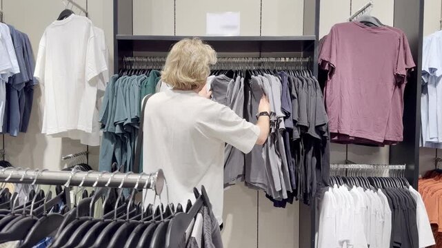 Clothes store in shopping mall.Blurred store aisle with hanging clothing racks