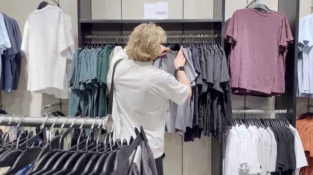 Clothes store in shopping mall.Blurred store aisle with hanging clothing racks