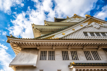 Fototapeta premium Upward low angle view of Osaka Castle rooflines and gilded shachihoko,