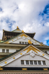 Obraz premium Upward low angle view of Osaka Castle rooflines and gilded shachihoko,