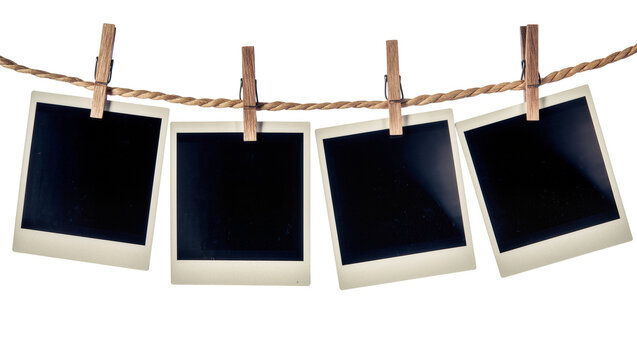 Four empty instant photo frames hanging on a rope with clothespins, isolated on transparent background