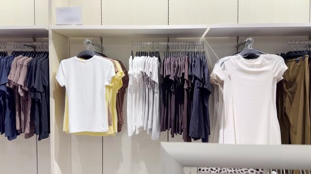 Clothes store in shopping mall.Blurred store aisle with hanging clothing racks