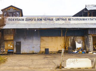 Busy metal recycling yard scene. Industrial recycling facility filled with debris and corrugated doors © ossyffer