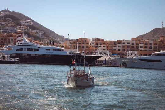 A view of the modern waterfront architecture and luxury hotels overlooking the busy marina filled with charter boats in Baja California Sur.