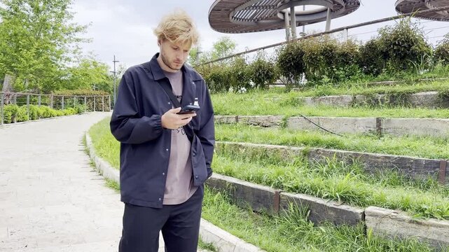 Lifestyle portrait of young man  using a smartphone outdoors