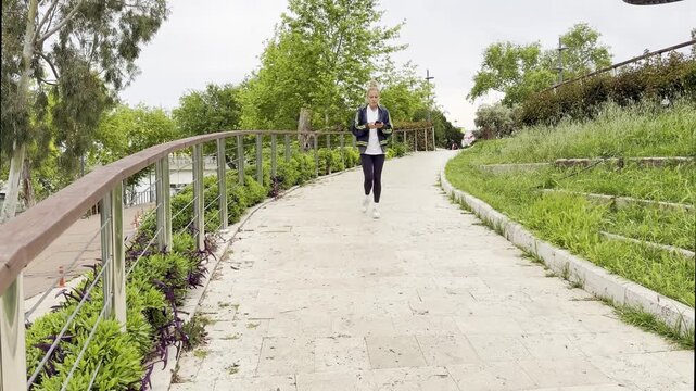 Lifestyle portrait of young woman  using a smartphone outdoors