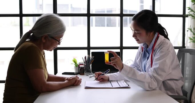 Doctor discussing treatment options with patient, holding a medicine bottle, explaining prescription for health and wellbeing during medical consultation in clinic