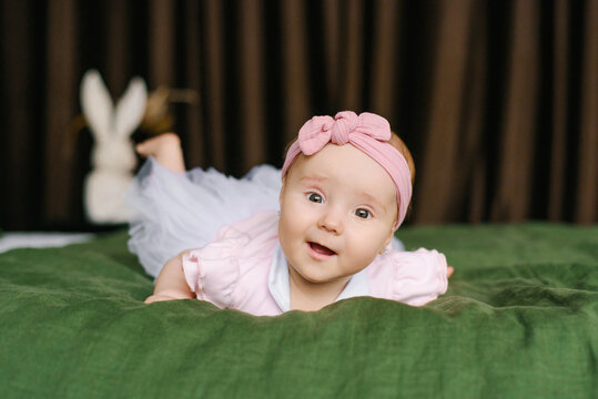 Baby Girl Smiling While Lying On Green Blanket