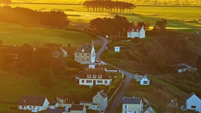 Golden hour tranquil French village roads, aerial view Port en Bessin