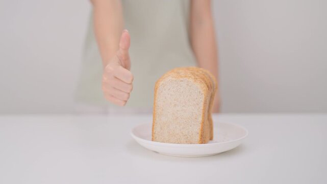 Happy smiling woman with whole wheat bread and thumbs up gesture. Weight loss, Dieting, Healthy eating, Calorie control, Fitness food, High fiber, Wellness, Lifestyle, Metabolism and Glycemic Index